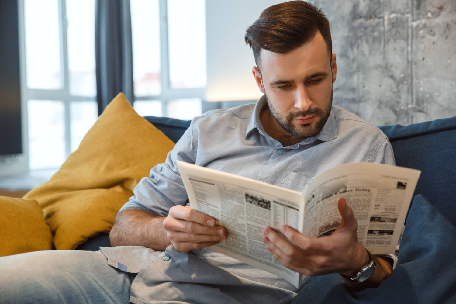 Homme lisant attentivement un journal d'annonces légales.